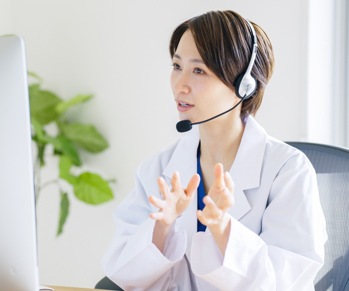 白衣を着たオペレーターがモニターを見ながら話をする様子